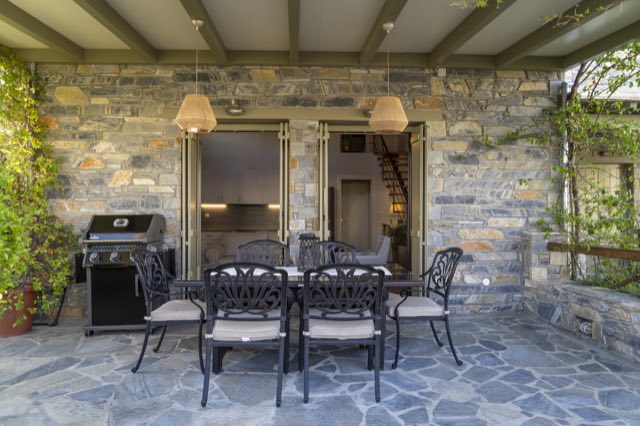 The covered patio by day, table and barbecue