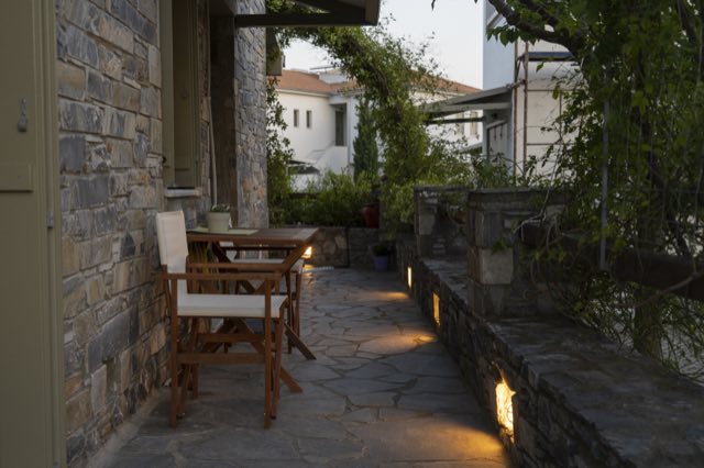 The side terrace at dusk, lit along the stone