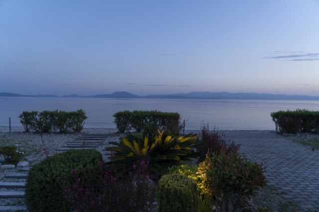 The garden steps down to the sea at dusk