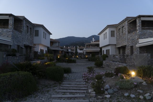 The garden path at dusk, lanterns lit along the stone