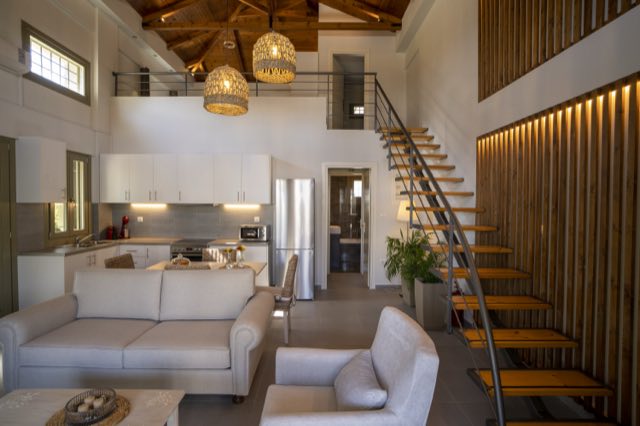 Sofa and armchairs, the kitchen and the staircase beyond