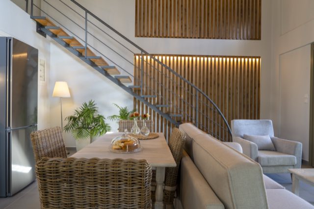 The dining table beside the staircase and the timber wall
