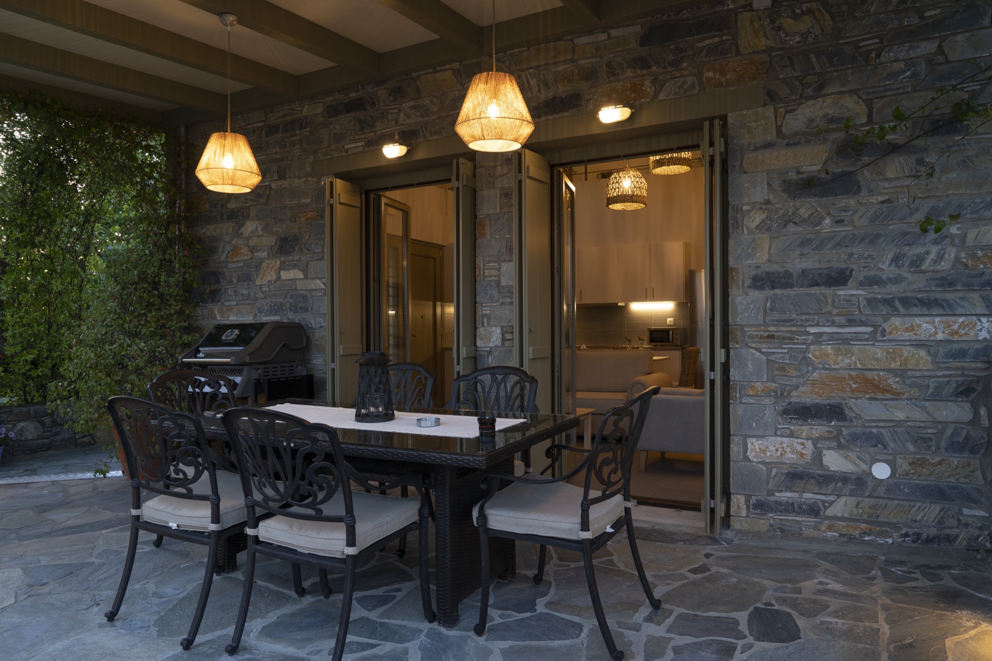 The covered patio at dusk, with the barbecue and the lanterns lit
