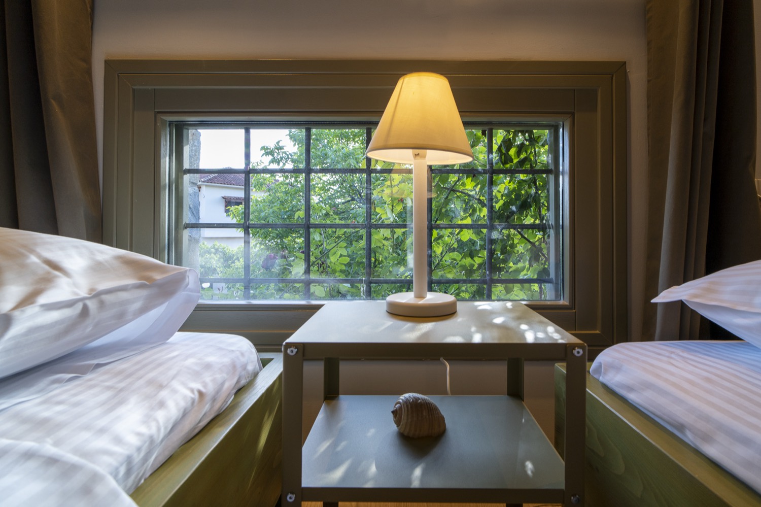 Bedside table and lamp between the two single beds