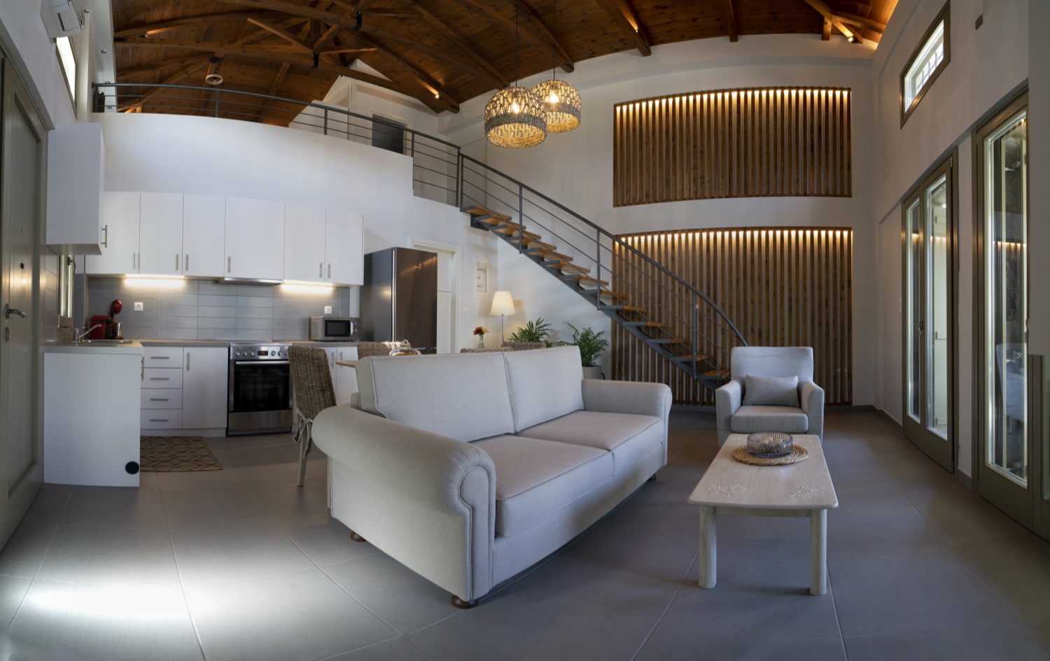 Open-plan living room and kitchen beneath the timber ceiling